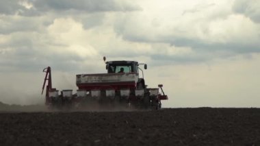 tractor works in the field. sowing corn. precision farming