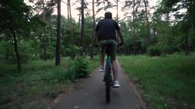 young guy rides a bike in the park. motion