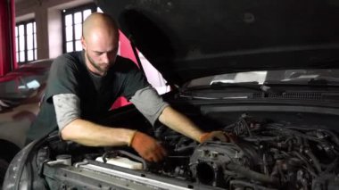 Otomobil tamircisi bir SUV motoru teşhis ediyor. otomatik tamir istasyonu.