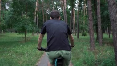 young guy rides a bike in the park. motion.