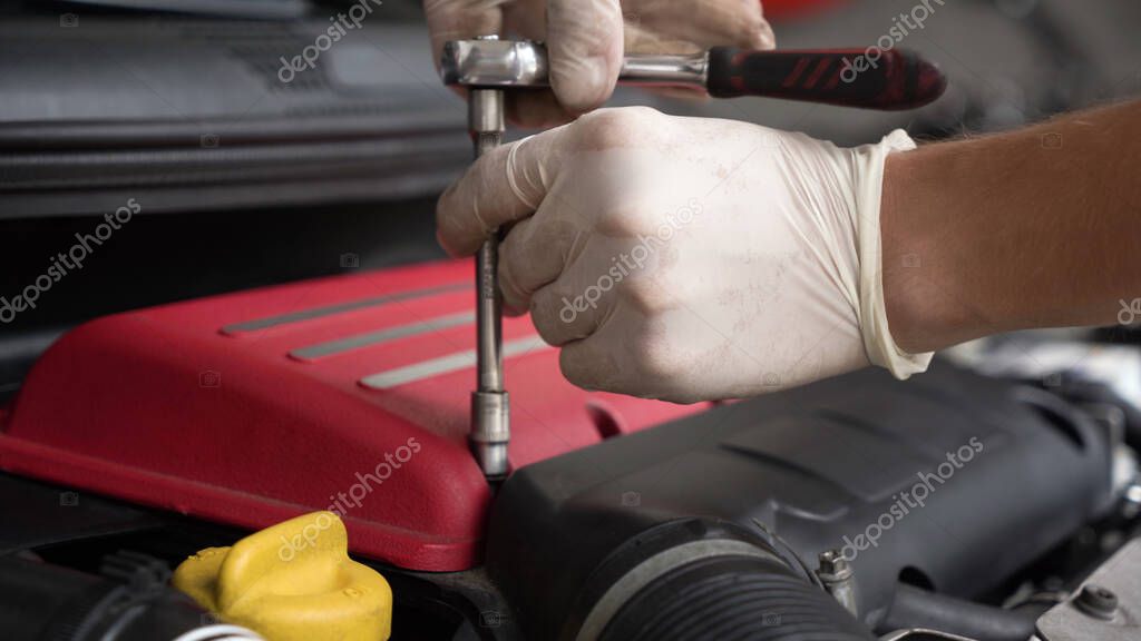 Автомеханик ремонтирует двигатель автомобиля. автомобильный сервис ...
