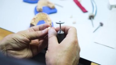 Diş teknisyeni atölyesinde çalışıyor ve dişçilik için yapay diş yapıyor. laboratuvar.