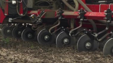 Tarlaya mısır tohumları ekiyor. Traktör bir ekiciyle tarlada çalışıyor. yakın plan