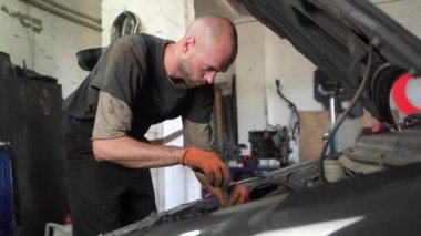 Otomobil tamircisi araba motorunu tamir eder. oto tamirhanesi.