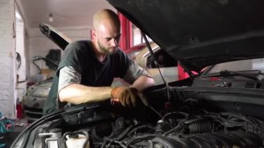 Otomobil tamircisi bir SUV motoru teşhis ediyor. oto tamirhanesi