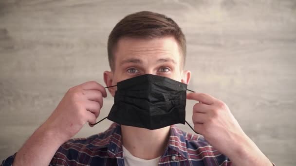 Καυκάσιος Άνθρωπος Που Βάζει Ιατρική Προστατευτική Μαύρη Μάσκα Προσώπου Κοιτάζοντας — Αρχείο Βίντεο