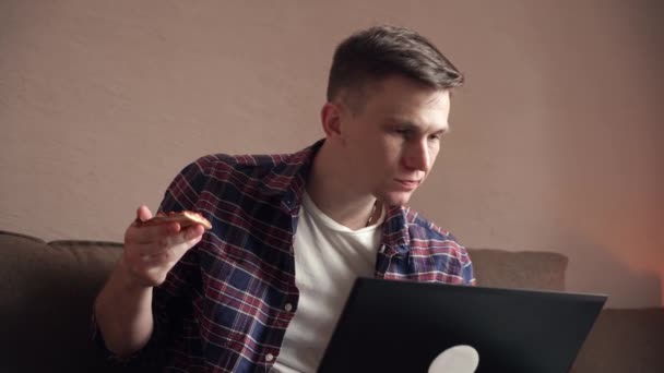 Jovem Feliz Come Pizza Trabalha Computador Interior Casa Trabalho Remoto — Vídeo de Stock