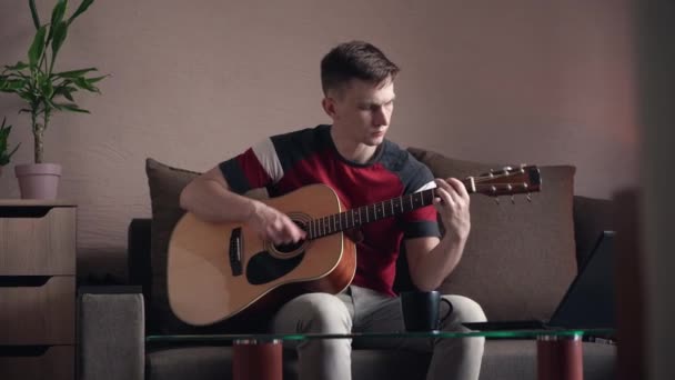 年轻人在家里学习在网上弹奏吉他 — 图库视频影像