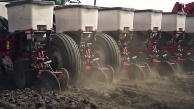 Tarlaya mısır tohumları ekiyor. Traktör bir ekiciyle tarlada çalışıyor. yakın plan