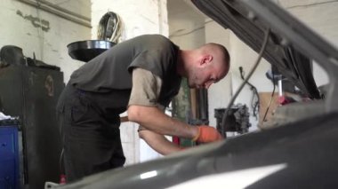 Otomobil tamircisi araba motorunu tamir eder. Araba tamircisi. tanılar