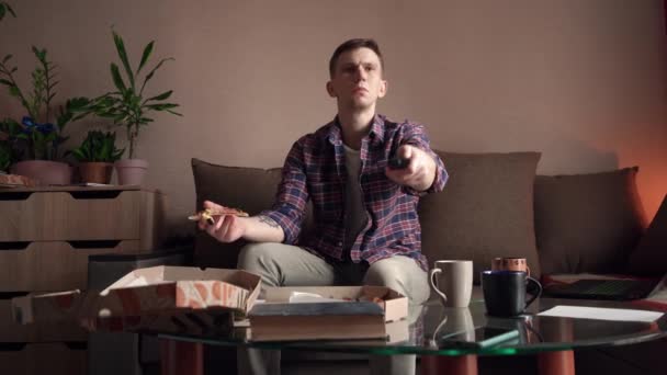 Szczęśliwy Młody Człowiek Pizzę Oglądając Telewizję Domu — Wideo stockowe