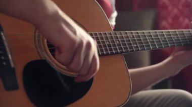 Mutlu genç adam akustik gitar çalar. yakın plan