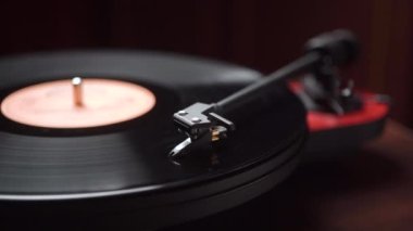 Adam rahat bir odada vinil çalar yapmaya başlıyor. yakın plan.