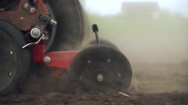Tarlaya mısır tohumları ekiyor. Traktör bir ekiciyle tarlada çalışıyor..