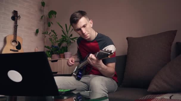 Молодой Человек Учится Играть Электрогитаре Онлайн Дома — стоковое видео