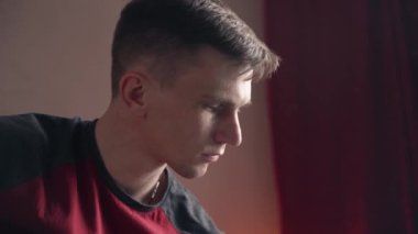 Mutlu genç adam akustik gitar çalar.