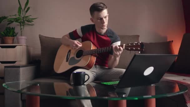 年轻人在家里学习在网上弹奏吉他 — 图库视频影像