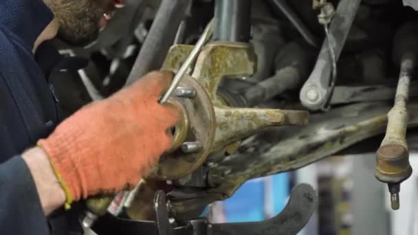 高加索秃头汽车修理工修理一辆旧车的底盘 汽车修理店 — 图库视频影像