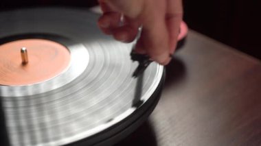 Adam vinil çalar çalıştırıyor. Karanlık bir oda. yakın plan