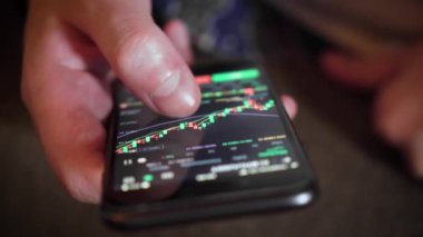 İşadamı, cep telefonu ekranındaki dijital bir değiş tokuşun fiyat tablosunu kontrol ediyor. yakın plan.