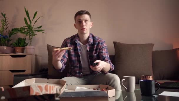 Feliz Joven Está Comiendo Pizza Mientras Televisión Sentada Casa — Vídeos de Stock