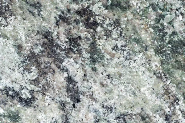 A heterogeneous texture of granite slab. Granitic rock. The coarse-grained plutonic rock structure