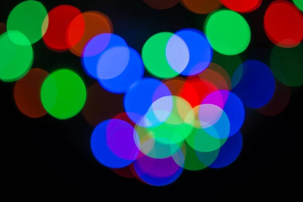 Bokeh ışık daireleri arka plan. RGB renklerinde odaklanmamış Noel ışıkları.