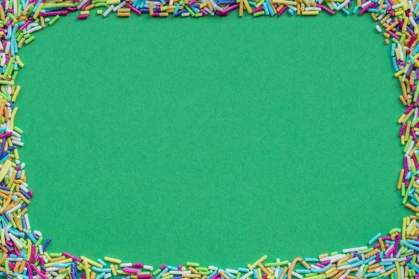 ロッド状のスプリンクルで作られたフレームに囲まれた緑の紙シート コピースペース付きクリスマスグリーティングカード — ストック写真