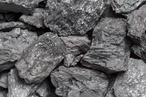 A heap of bituminous coal stone rock lumps. Non-renewable energy source. Natural fuel.