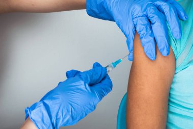 Çocukların hemşiresi küçük kahverengi kızın koluna iğne yapıyor, doktorun ellerine kovid 19 enjekte eden lastik eldivenler ya da grip aşısı. tıbbi, sağlık ve salgın konsepti