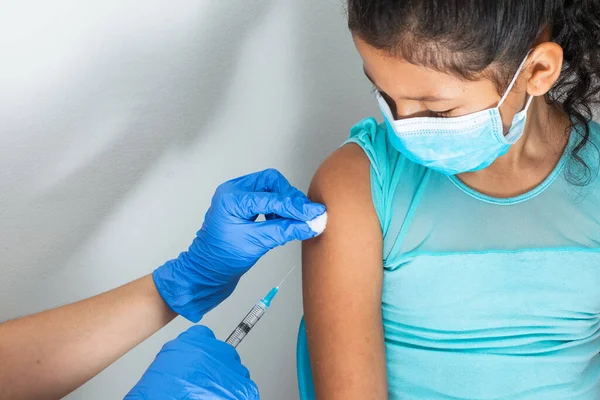 茶色の女の子の腕に注射した後子供の看護師は綿のウールで血液を拭く 医者はコヴィド 19にワクチンを注射する インフルエンザワクチン 医療の概念と健康とパンデミック — ストック写真