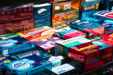 Eczane vitrininde Dristan, Advil çocuklar, Aspirin coşkusu, Sevedol, Durafex, Naproxen, Diclofenac sodyumu, Noxpirin, grip ve malaise ilaçları gibi haplar bulunuyor..