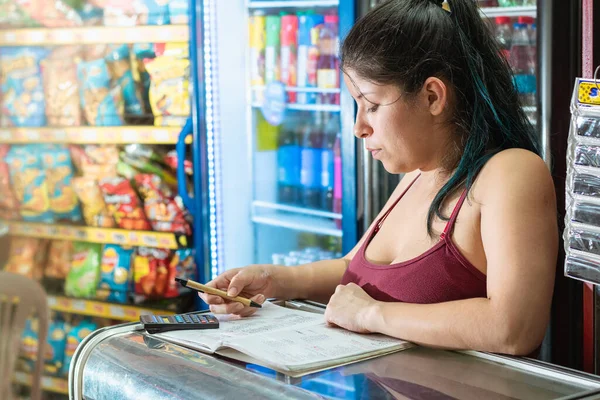 Mujer Latina Concentrándose Mientras Calcula Número Ventas Cuaderno Tienda Comestibles — Foto de Stock
