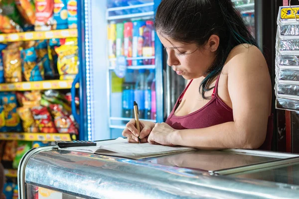 Mujer Latina Concentrándose Escribir Cuaderno Contabilidad Tienda Vecinal Chica Apoyada — Foto de Stock