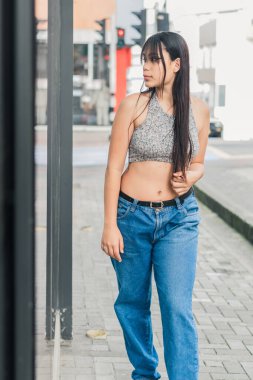 Güzel Latin esmer kadın Pereira-Kolombiya şehrinde sokakta aynanın yanında duruyor. Bir giyim mağazasının yansımasında güzelliğine hayran olan genç bir kadın..