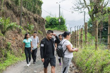 Bir grup Latin, görkemli Kolombiya dağlarında uzun bir yürüyüş yapıyor. İnsanlar çok fazla yürümekten yoruldu..