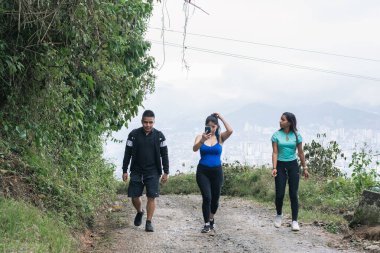 Zihinlerini boşaltmak ve temiz hava almak için şehirden ayrılan üç genç Latin. Kolombiya-Risaralda 'daki kahve ekseninin dağlarında yürüyorum. Özgürlük kavramı.