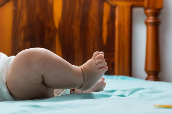 Közelkép Egy Latin Kislány Lábáról Aki Egy Kék Lepedős Ágyon — Stock Fotó