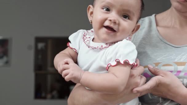 茶色の肌をした美しいラテン系の赤ちゃんの女の子 彼女の母親は彼女の腕の中で彼女を保持しながら 非常に幸せな彼女の手を保持 楽しそうな女の子 健康と健康の概念は — ストック動画