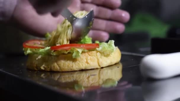 Детальний Знімок Приготування Колумбійського Вуличного Гамбургера Чоловік Наливає Хліб Салат — стокове відео