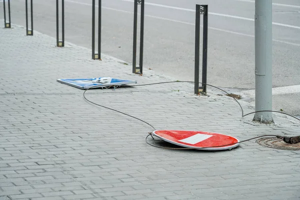 The road sign has fallen. The road sign is broken. Road. No travel. Stop sign. Pedestrian crossing sign. The wind blew off road signs.