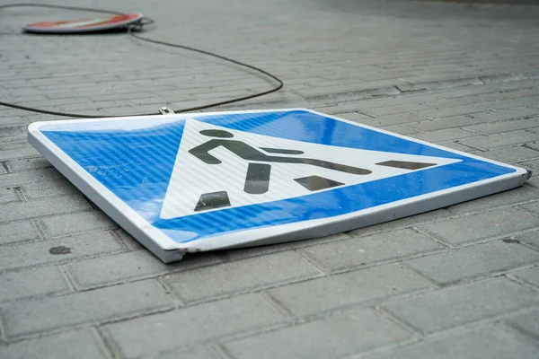 The road sign has fallen. The road sign is broken. Road. No travel. Stop sign. Pedestrian crossing sign. The wind blew off road signs.