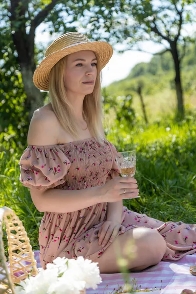 Beautiful woman in a straw hat with a glass of wine in hand. On vacation