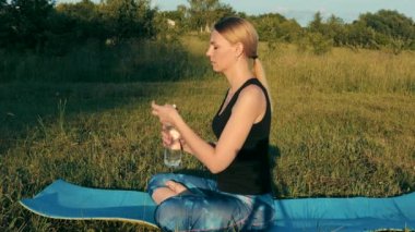 The girl drinks water after a morning workout