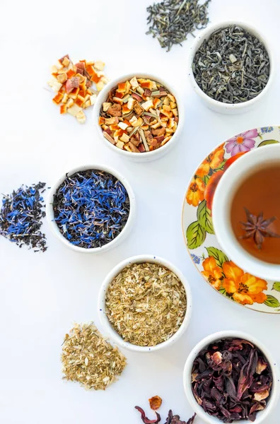 Dried herbal tea. Variety of dry tea in utensils, on white background,