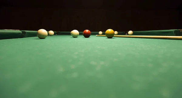 Billiard game, colorful balls and cue on green table