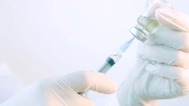 Family medicine. The doctor holds a syringe and a bottle with a vaccine for injections. The concept of treatment, injections, vaccinations and clinical trials. Close up