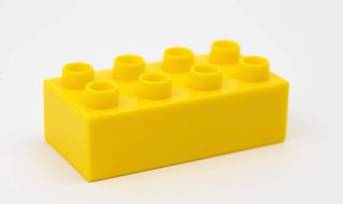 Beyaz arka planda sarı plastik yapı taşı