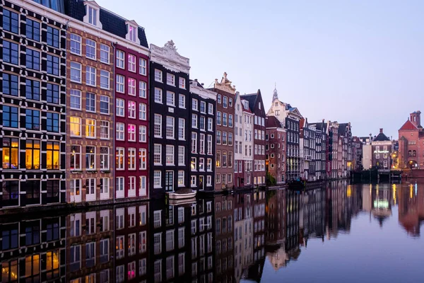 Amsterdam ufuk çizgisi: arka planda renkli evler dizisinin yansıması olan bir kanal manzarası