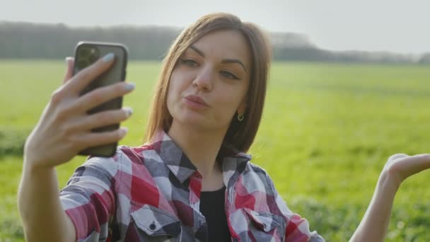 Młoda kobieta, rolnik blogger pokazuje zielone pole pszenicy na żywo — Wideo stockowe